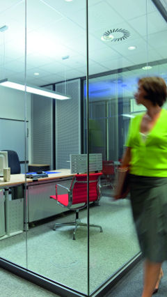 Žena nazerá do súkromných kancelárií Audi osvetlených spoločnosťou Philips Lighting.