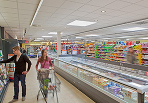 Pár prechádza uličkami supermarketu osvetlenými úspornými svietidlami spoločnosti Philips 