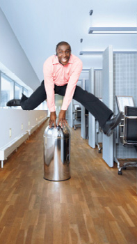 Muž skáče na chodbe kancelárie osvetlenej dynamickým osvetlením Philips.