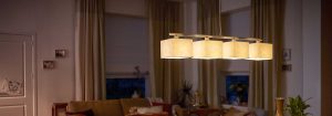 Moderné závesné LED svietidlo s viacerými látkovými odtieňmi osvetľuje útulnú obývaciu izbu a predstavuje energeticky účinné a štýlové riešenia domáceho osvetlenia pre príjemnú večernú pohodu.